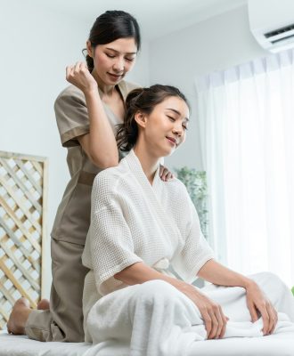 Asian young happy woman feeling relax during shoulder and back massage.